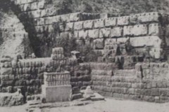 La tribune chorégraphique in situ au bas de l'angle nord du podium ; à côté, à droite, cippe pyramidal remis en place.